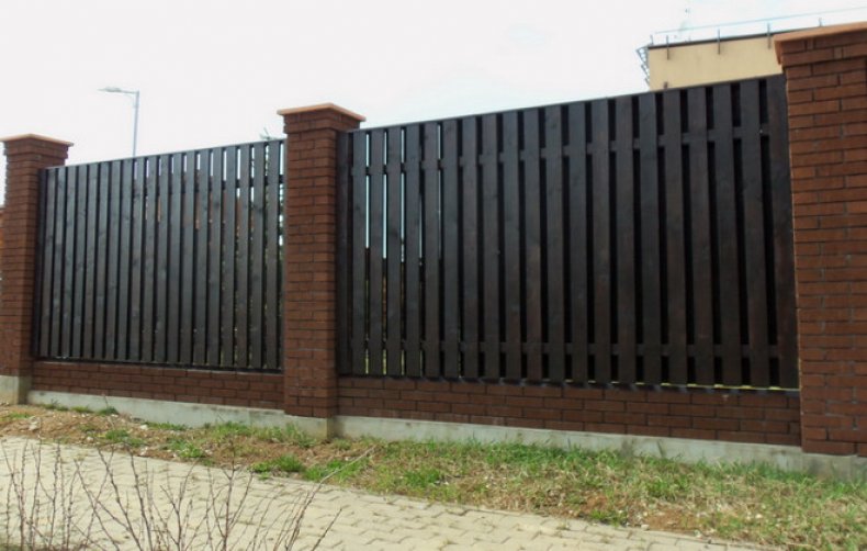 Кирпичный забор с деревянными ставками